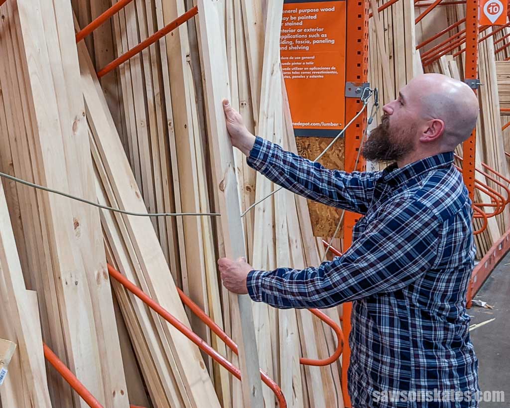Person removing a board from a home improvement store's rack
