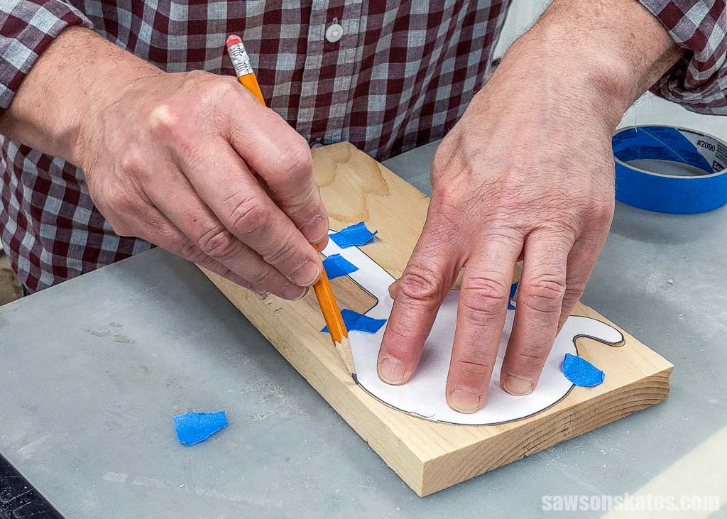Tracing a hook-and-ring game's template onto a piece of wood