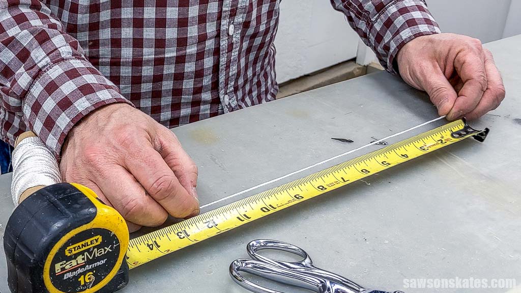 Hands holding a piece of string next to a tape measure
