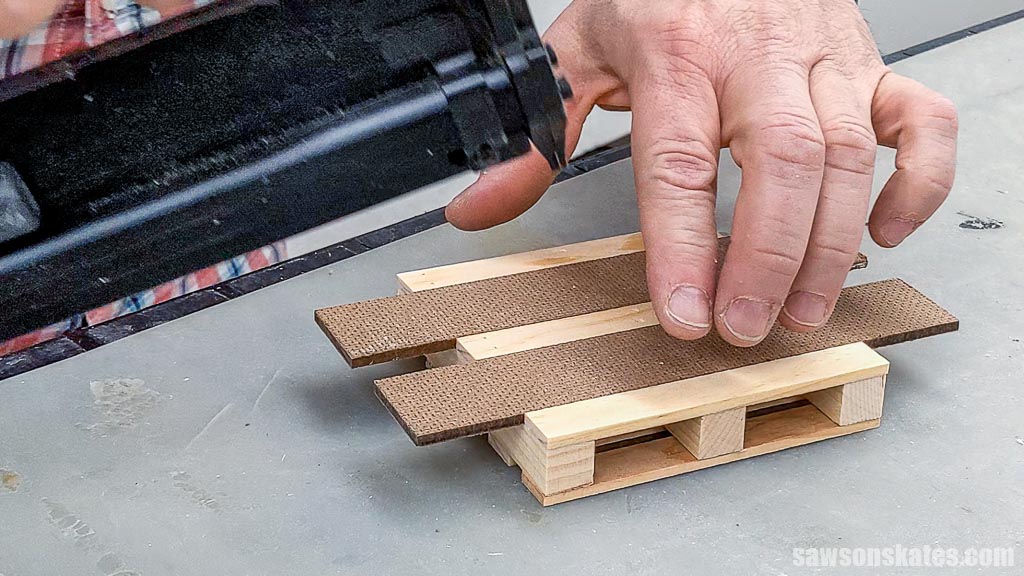 Attaching the last deck board to a mini pallet coaster's underside