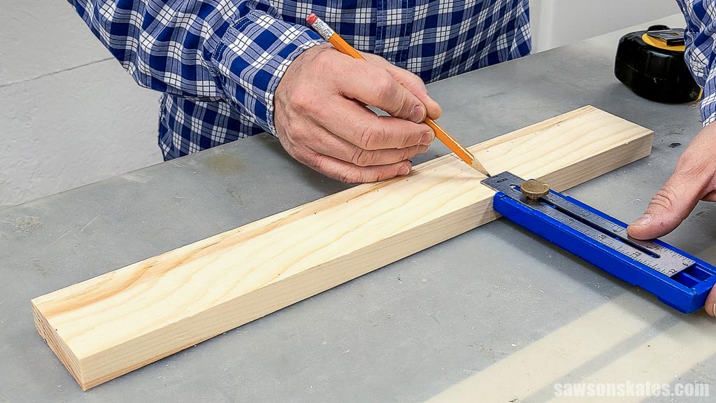 Using a pencil to mark the location for the center dowel holes on a DIY bow maker