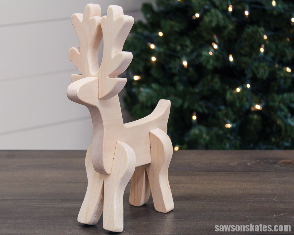DIY wooden tabletop reindeer on a table in front of a Christmas tree