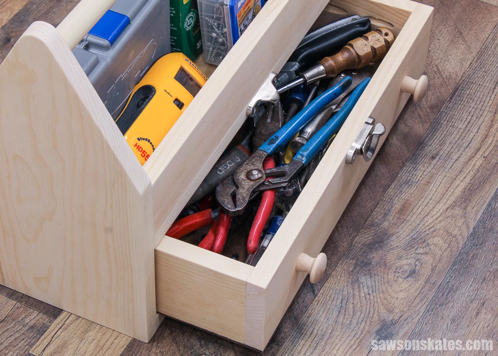 Top view of a DIY toolbox with it's drawer open filled with hand tools