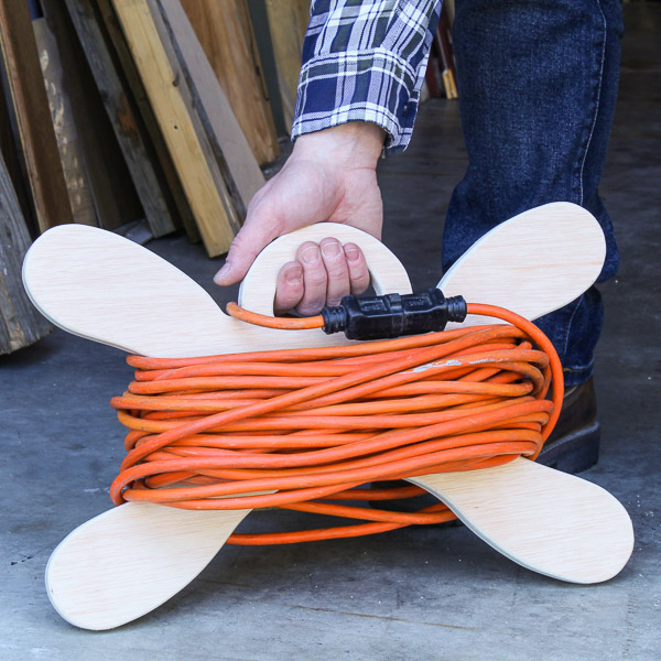 Hand picking up a DIY extension cord holder
