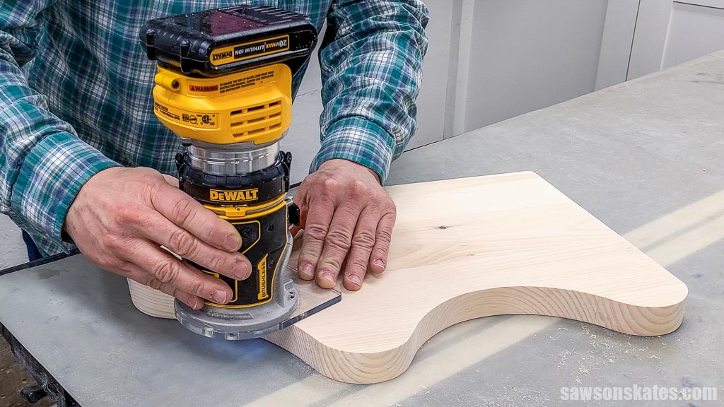Using a router to small the sharp edges of a DIY kitchen shelf's side panel