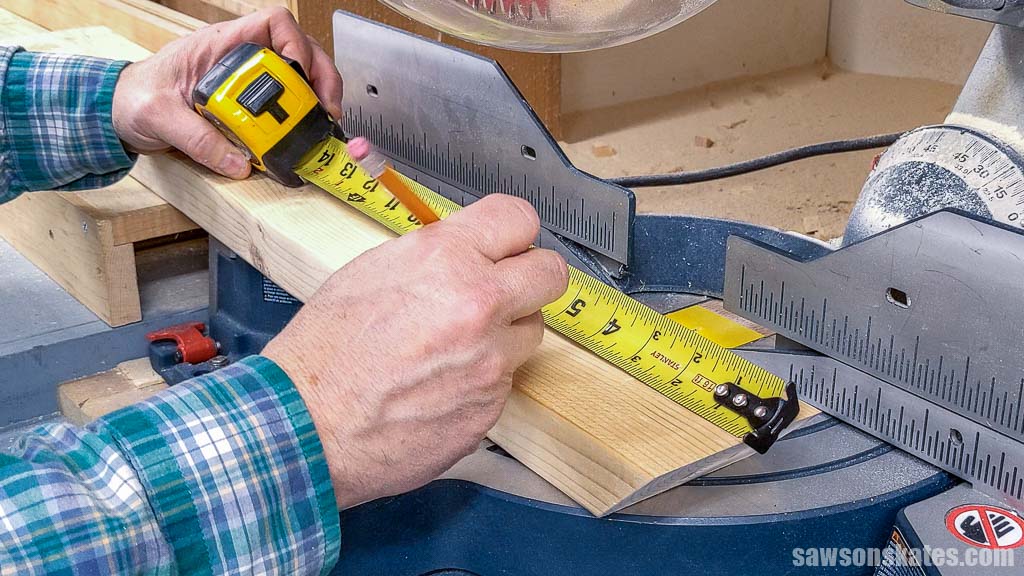 Using a tape measure to mark the length of a board