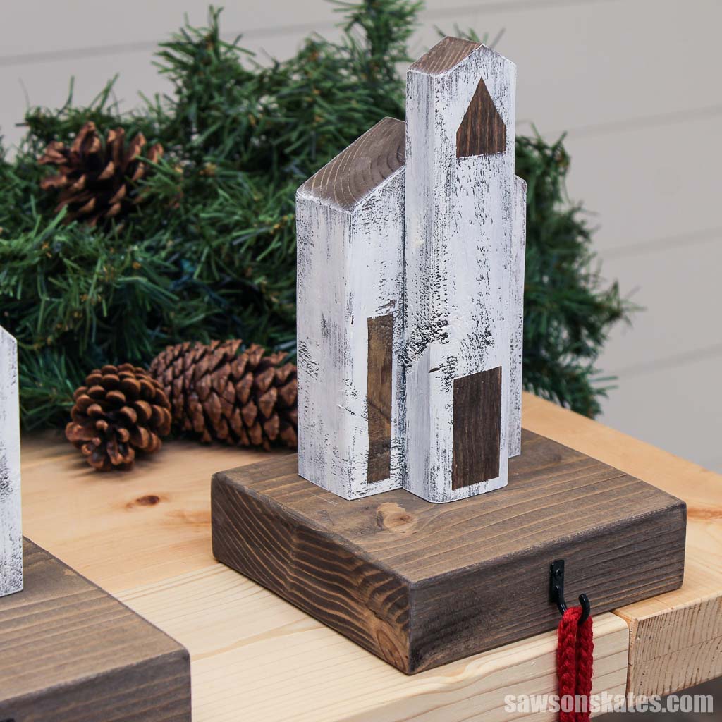 Church-style DIY wooden Christmas village stocking holder on the corner of a table