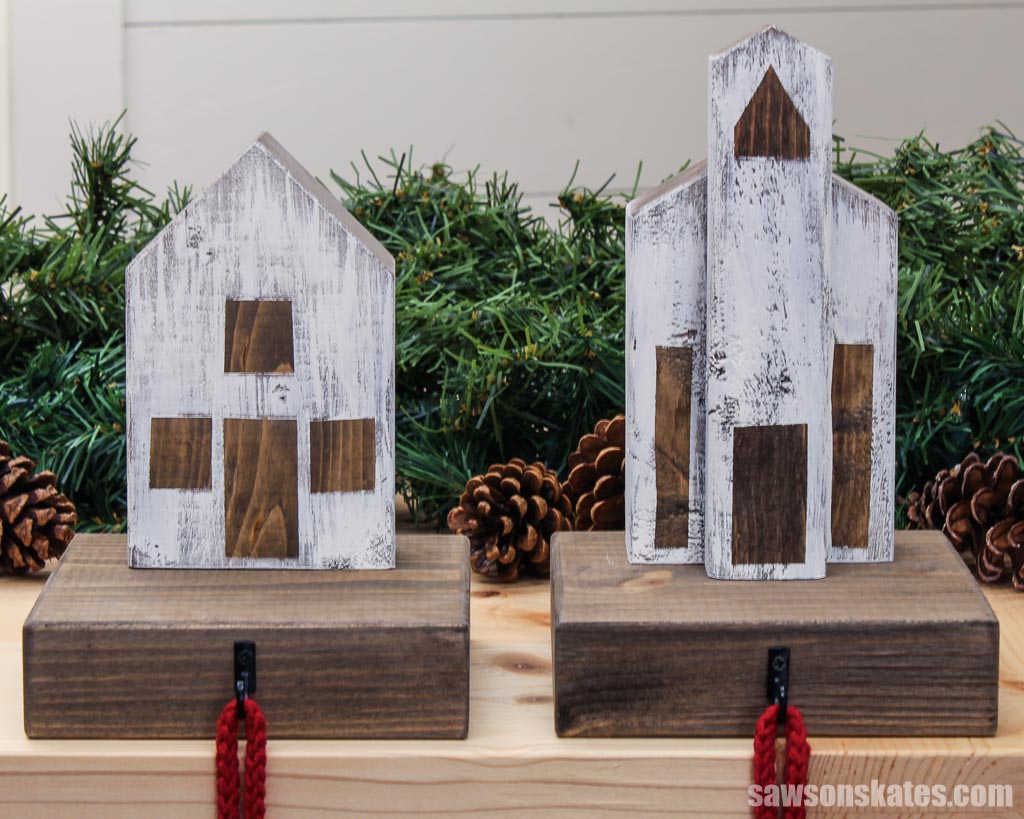 Wooden cottage and church-style Christmas village stocking holders