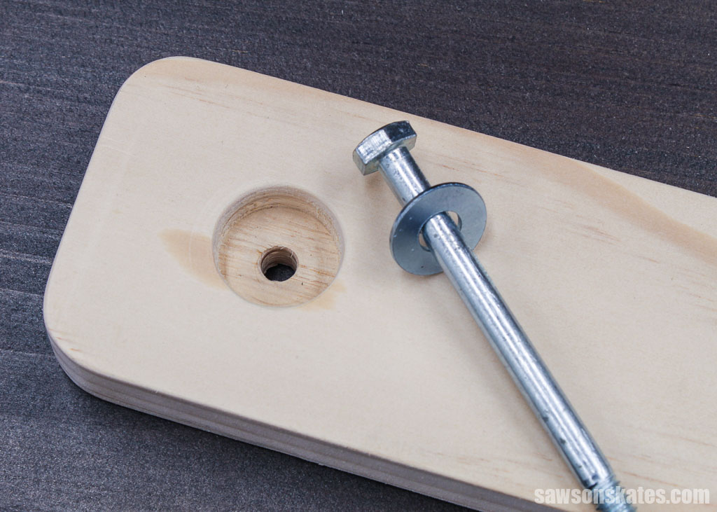 Lag bolt laying on a board with a countersink hole