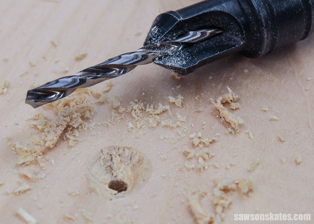 Close up of a countersink bit next to a countersink hole