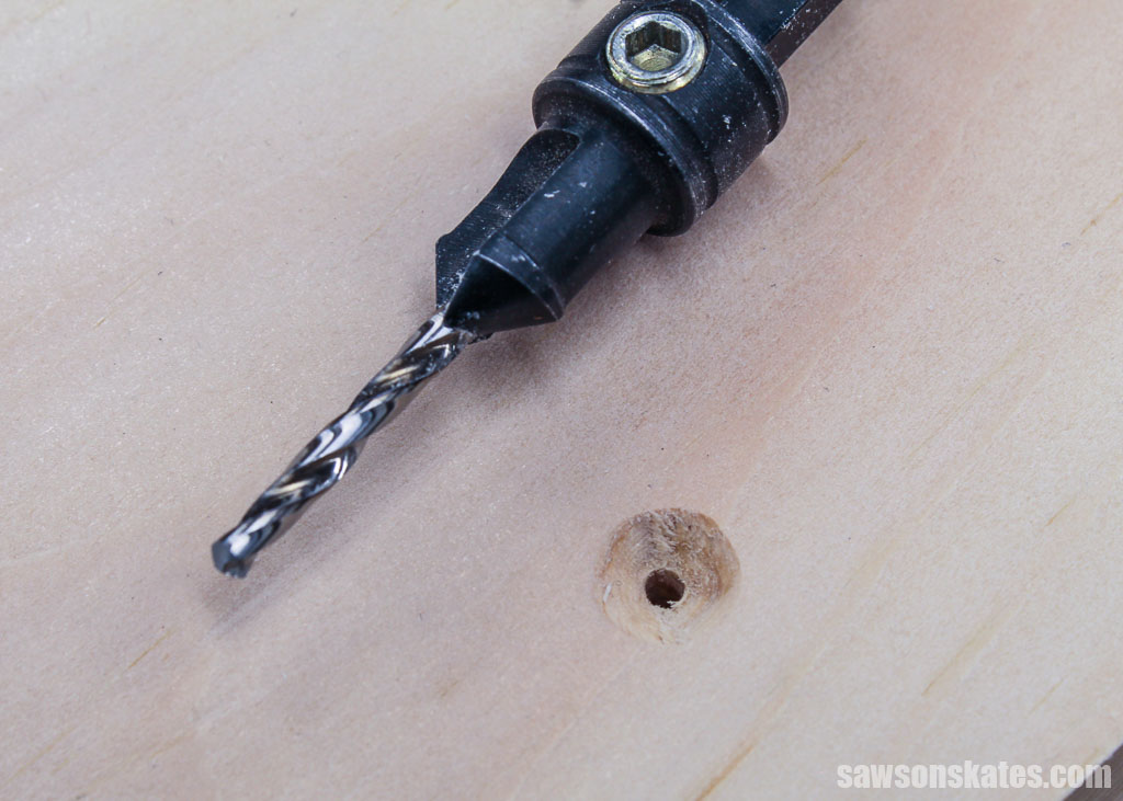 Countersink drill bit laying next to a countersink hole