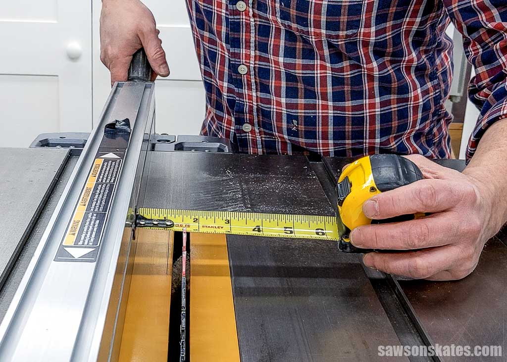 Using a tape measure to set a table saw's rip fence to cut a 2x4 in half