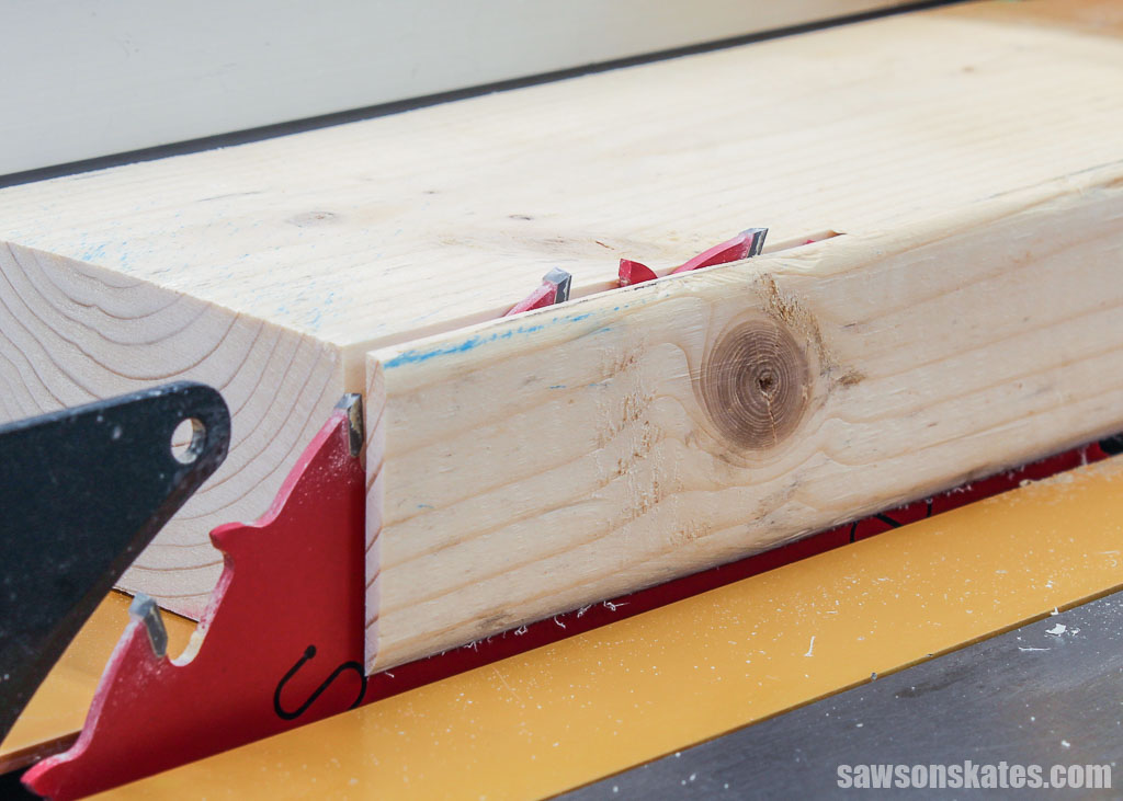 Close up of a table saw's blade height cutting a 2x4