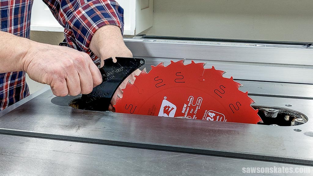 Hands installing a table saw's riving knife