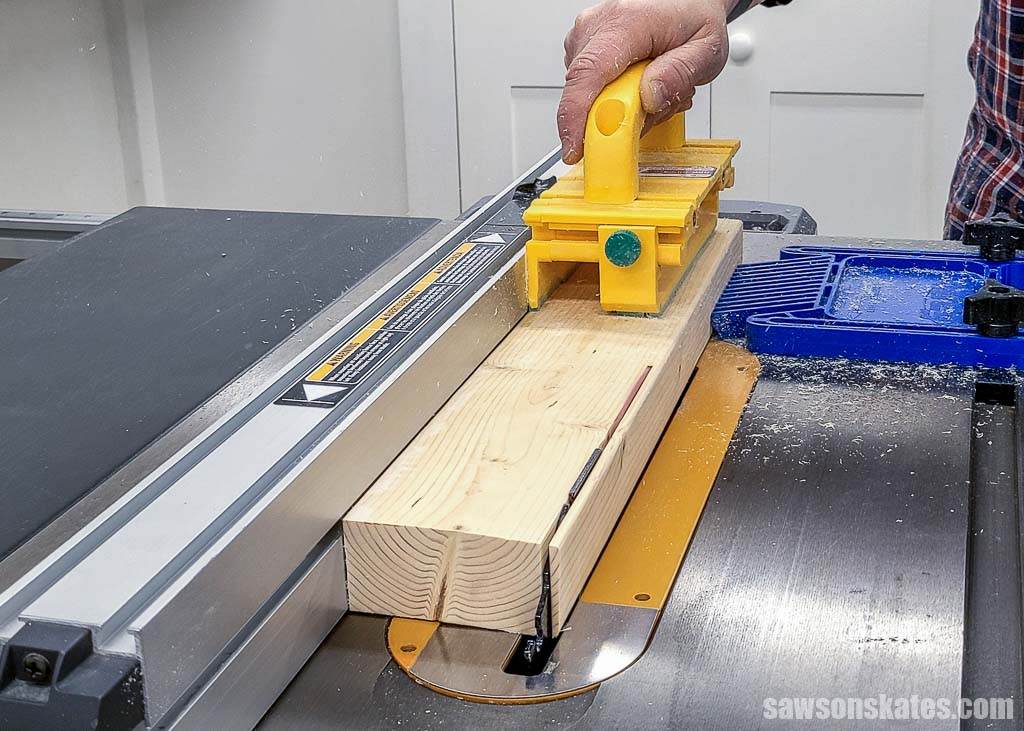Cutting a 2x4 lengthwise with table saw to remove it's second round edge