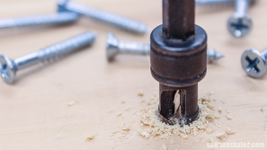 Countersink bit drilling a hole with screws in the background