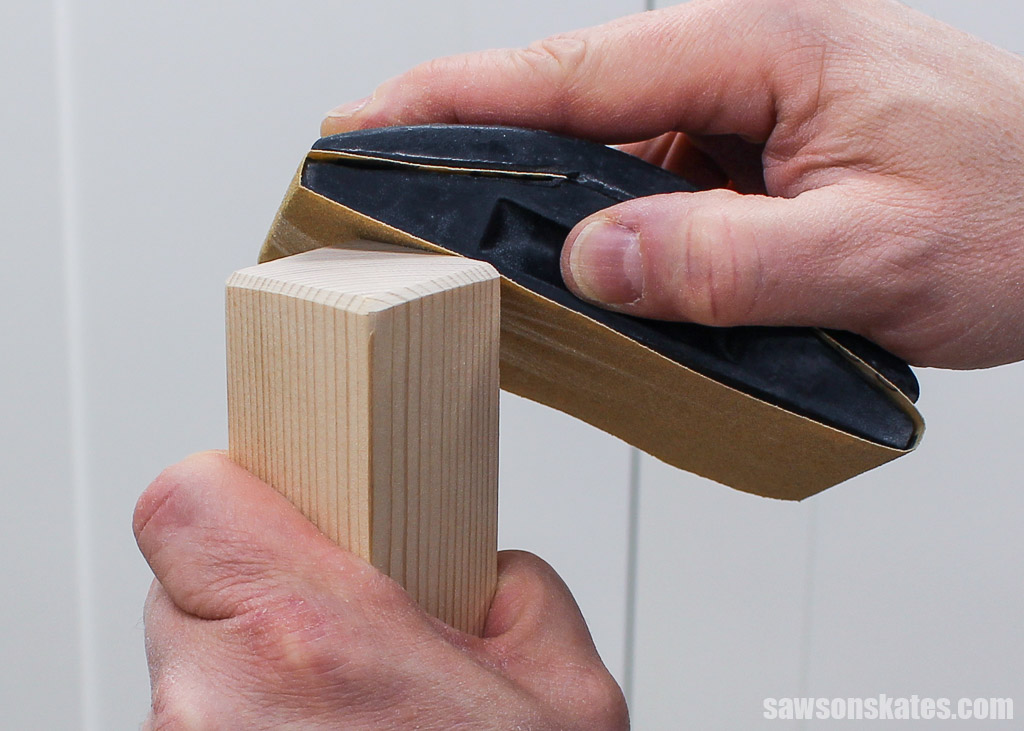 Sanding a bevel on the bottom of a furniture leg to prevent snags