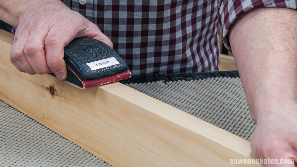 Smoothing the edge of a board with a sanding block
