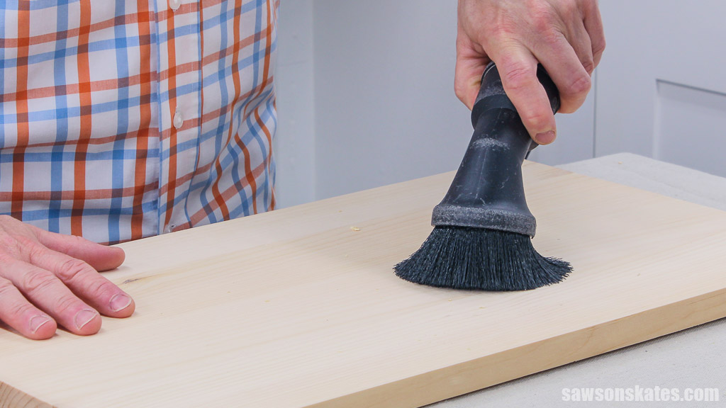 Using a ShopVac to vacuuming a piece of wood between switching sandpaper grits
