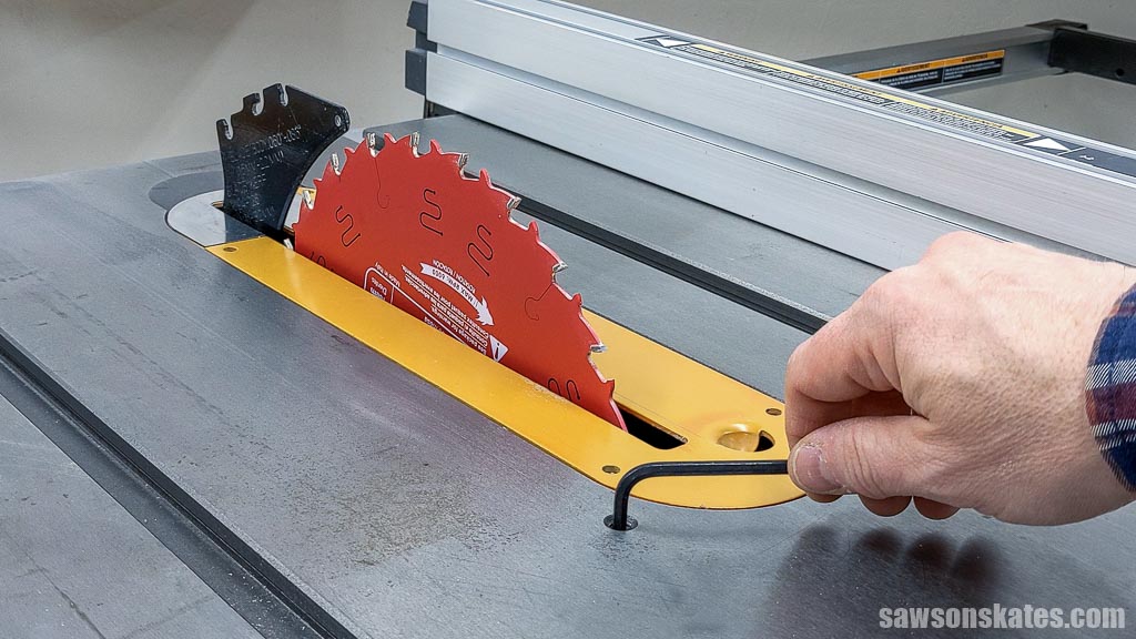 Tightening a set screw to adjust a table saws stop