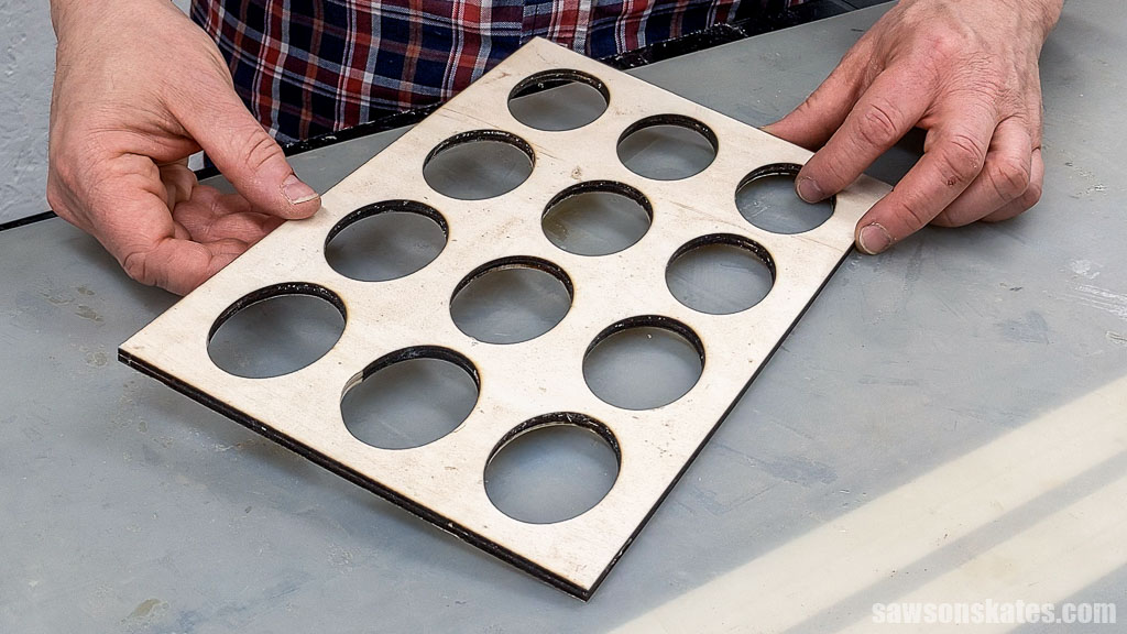 Hands holding a template made with a laser cutter for a deviled egg tray