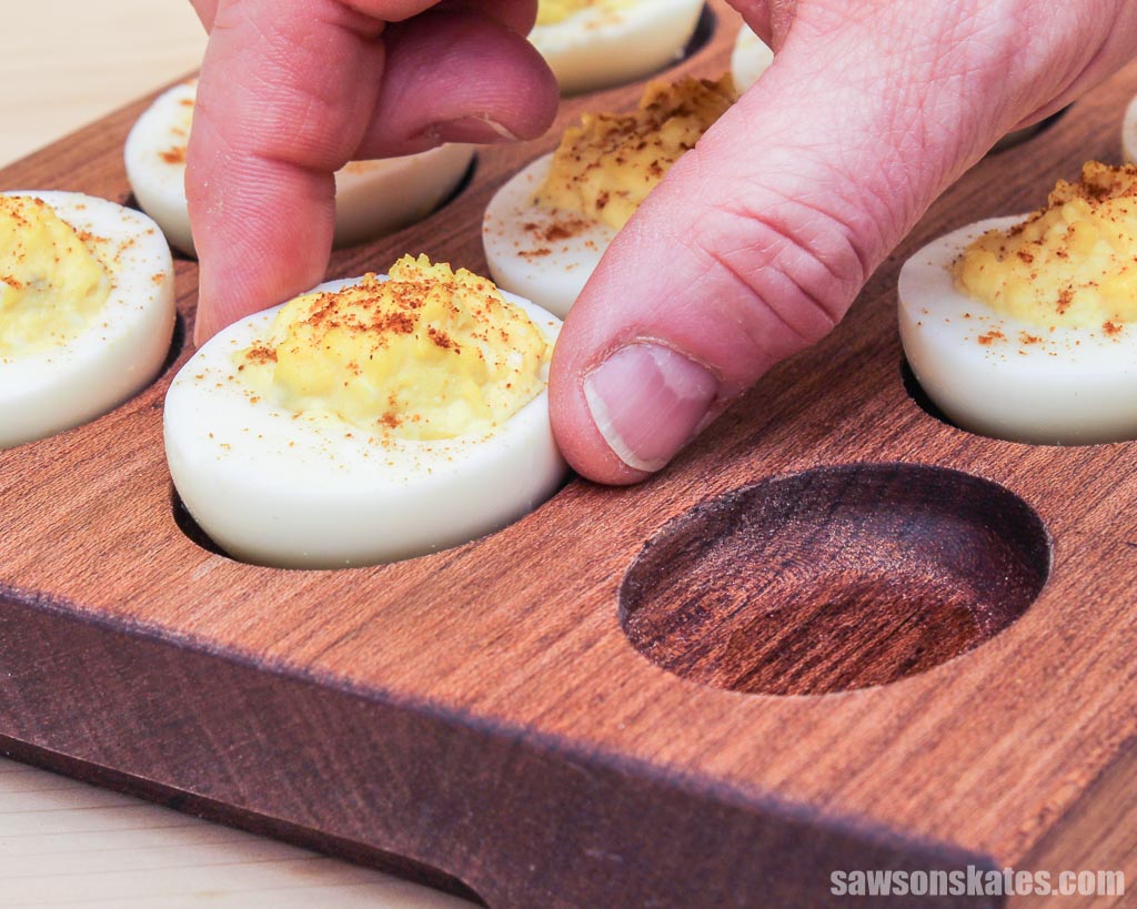 Hand removing an egg from a DIY deviled egg board