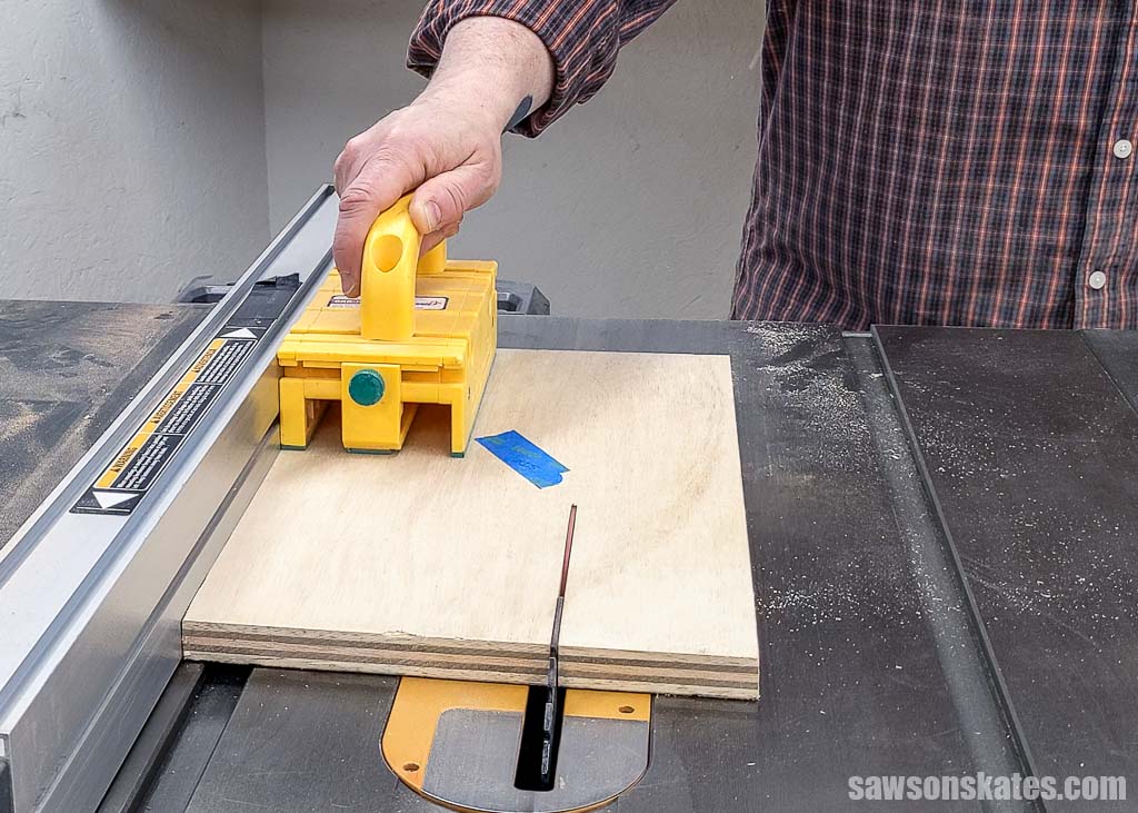 Using a table saw to rip a piece of plywood to width