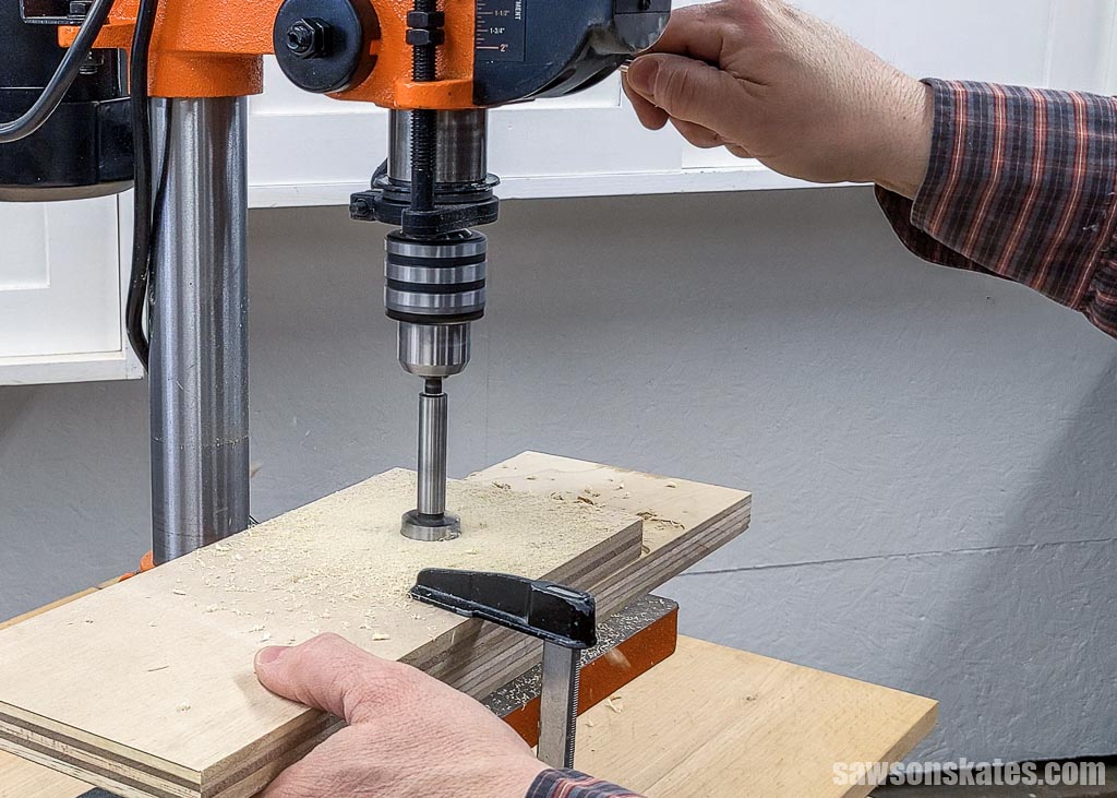 Using a drill press to make a hole in the top shelf of a DIY jig saw holder