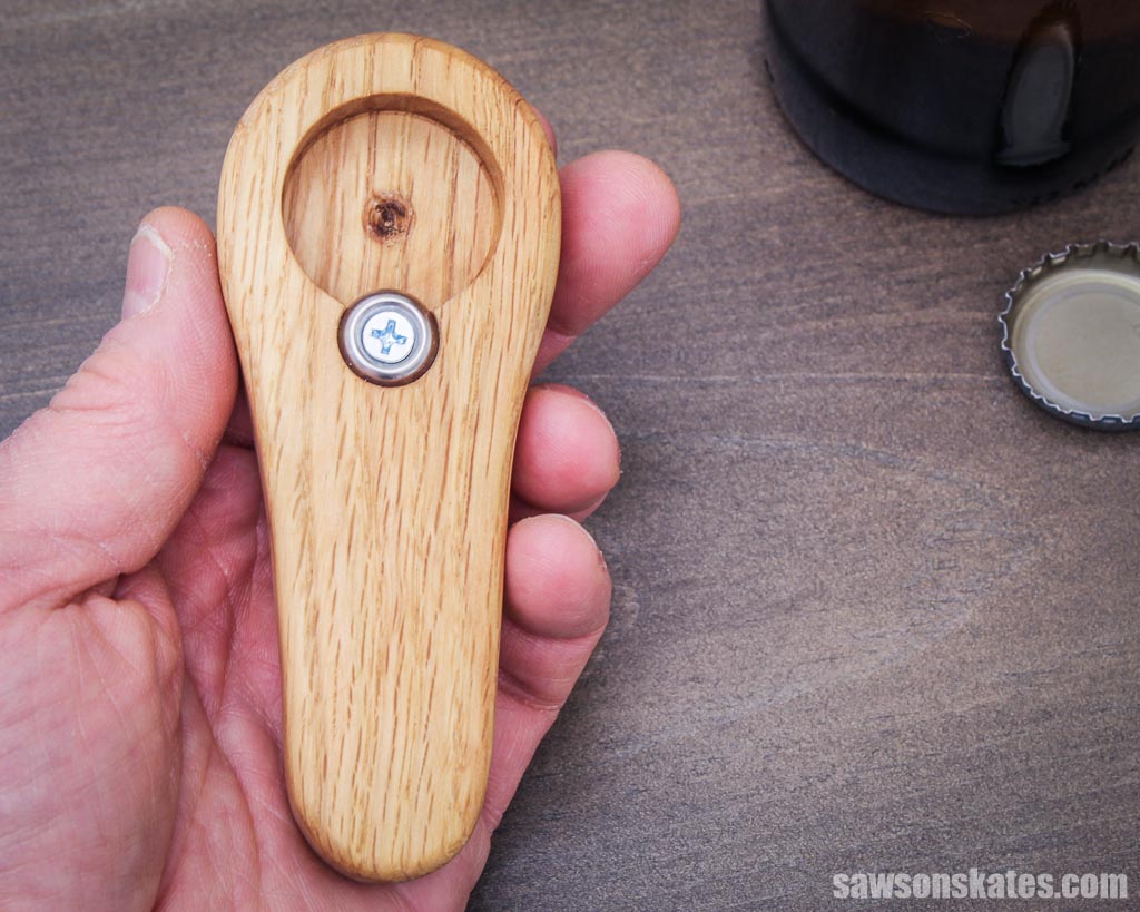 Hand holding a homemade wooden bottle opener