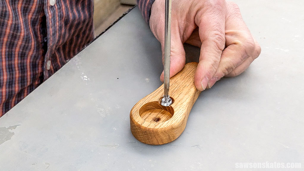 Attaching a washer to a handheld DIY bottle opener with a screw