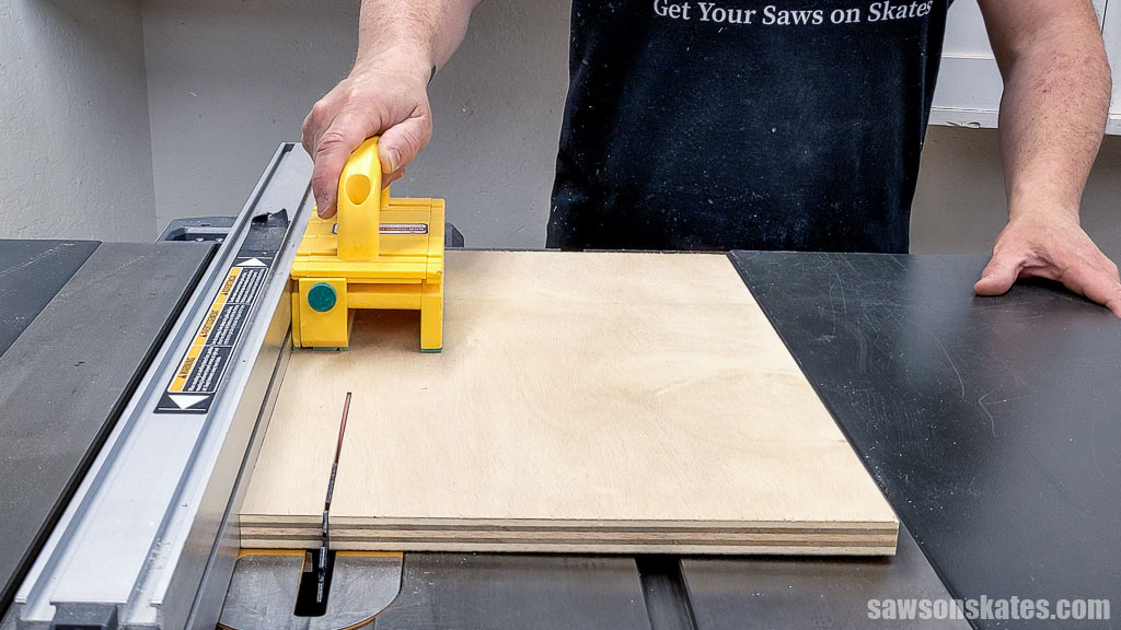 Using a table saw to rip a piece of plywood to width
