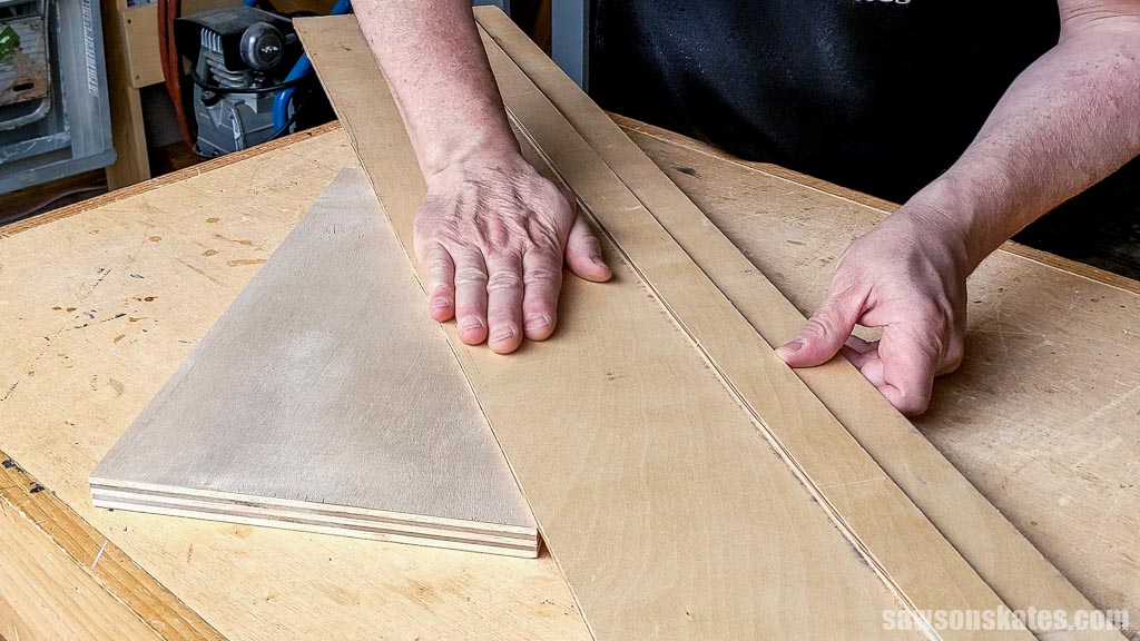 Pressing a crosscut jig onto a piece of plywood