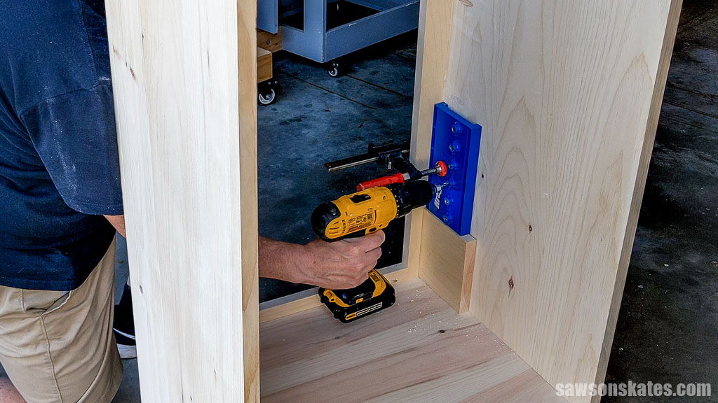 Drilling the first set of shelf pin holes in the cabinet's front