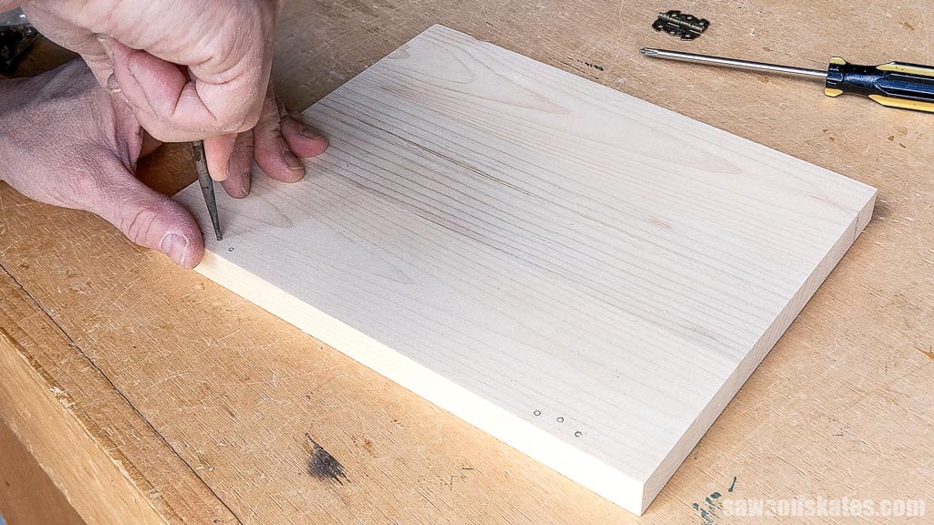 Making a starting point for a drill bit with an awl