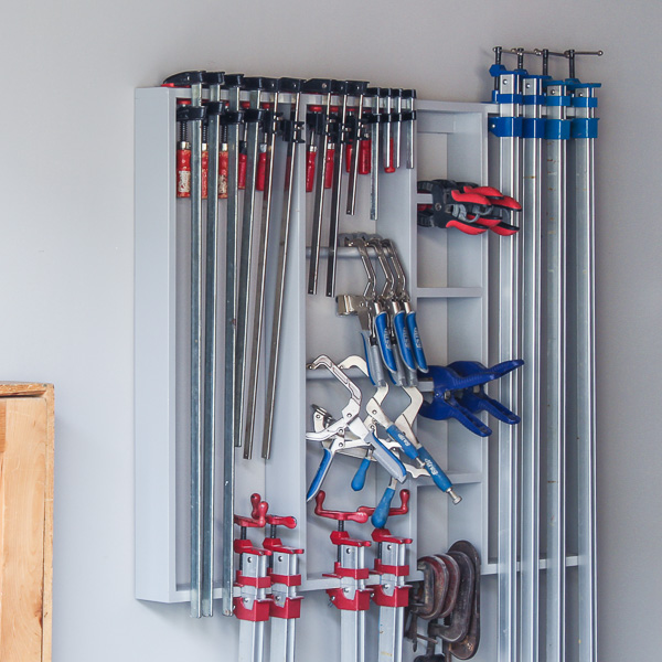 Woodworking clamps stored on a wall-mounted rack