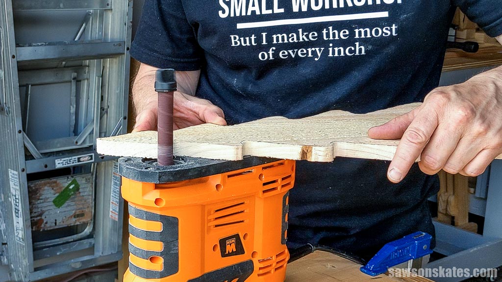 Smoothing a Christmas tree shape with a portable spindle sander