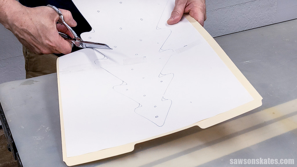 Cutting out a Christmas tree pattern with scissors