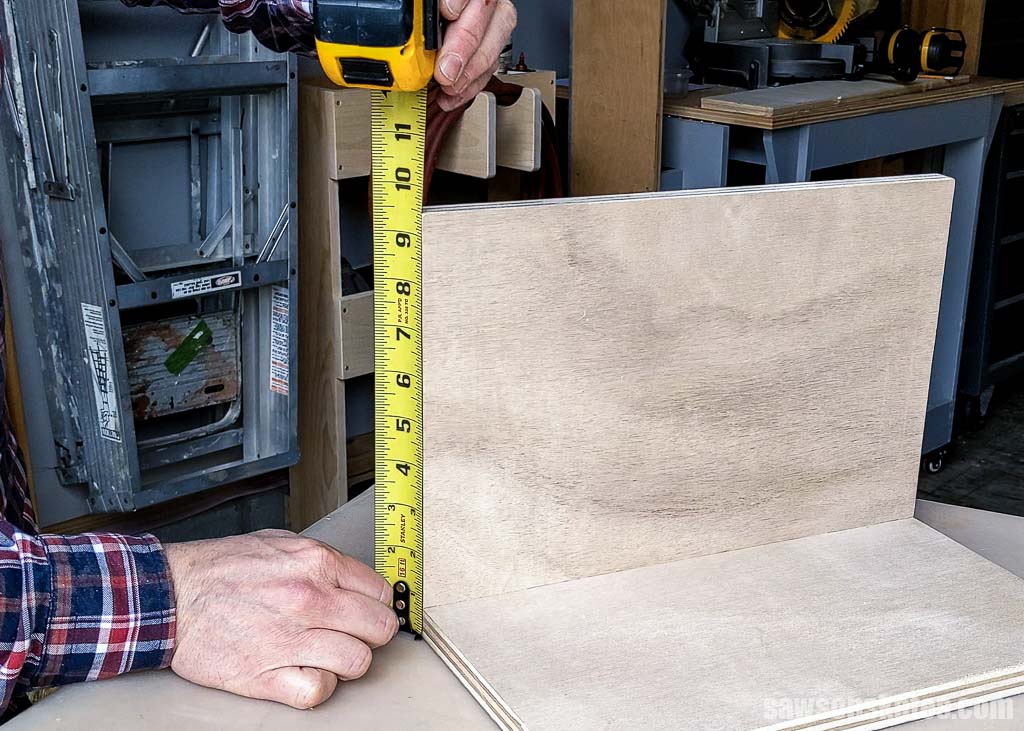 Measuring a piece of wood with a tape measure