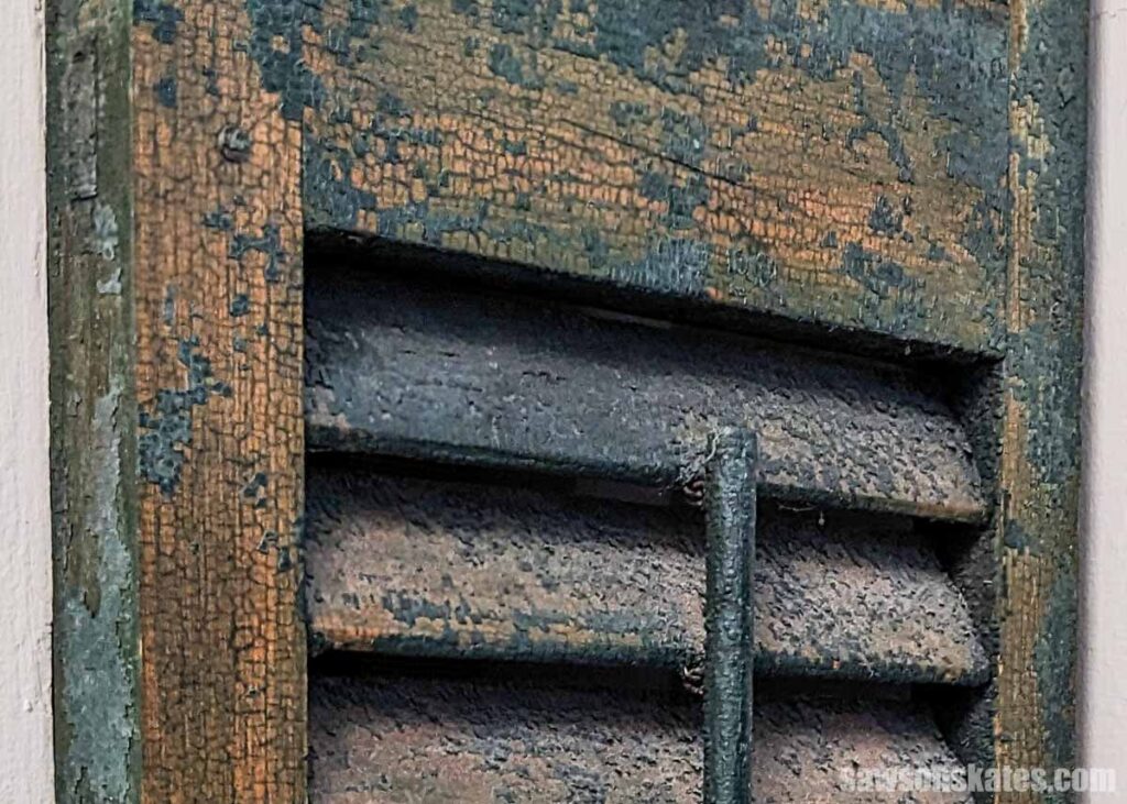 And old green shutter with paint chipping off