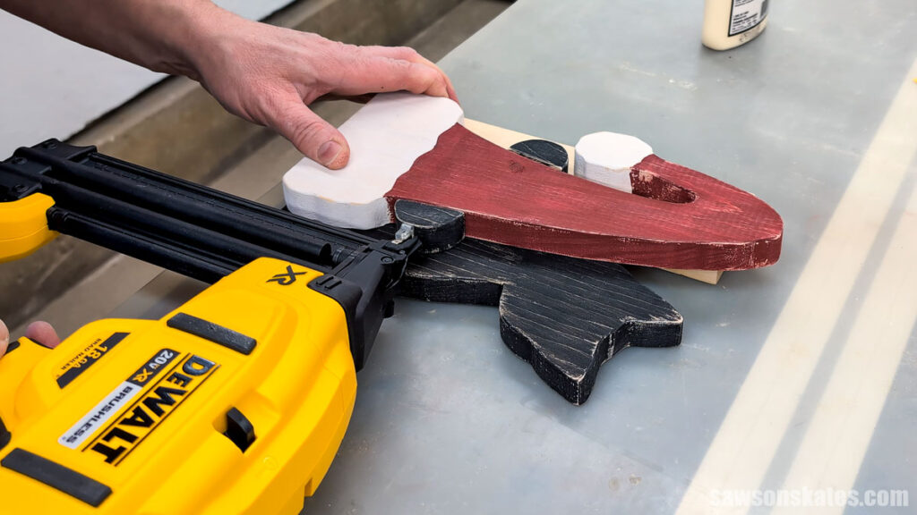 Attaching the cat's paw to the hat using a brad nailer.