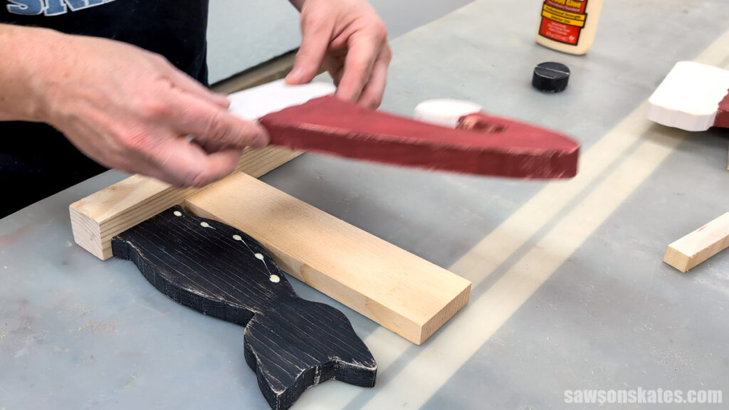 Placing the wood Santa hat on the cat