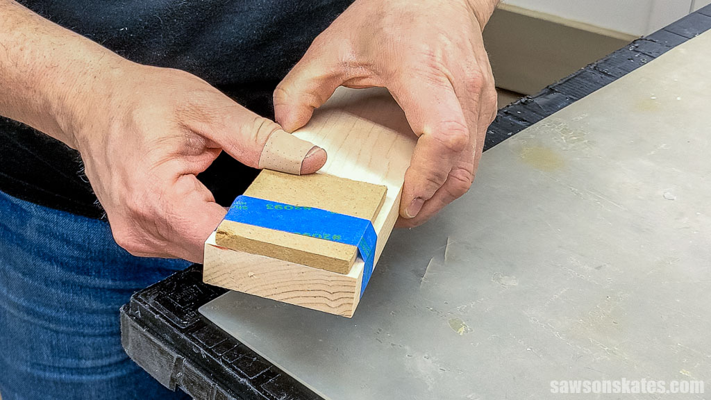 Hands holding board with an MDF spacer attached with painter's tape