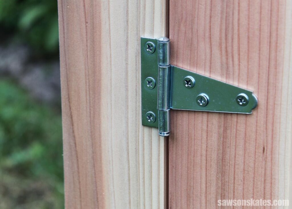 Closeup of a hinge on a DIY outdoor storage box