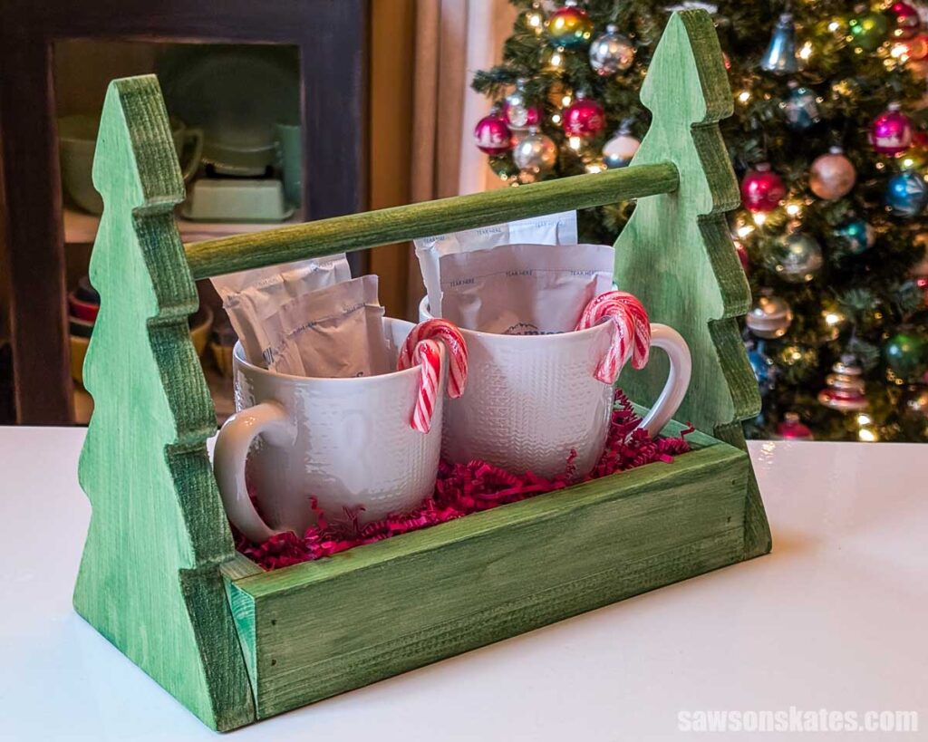 Three-quarter view of green-painted hot chocolate holder with Christmas tree-shaped sides