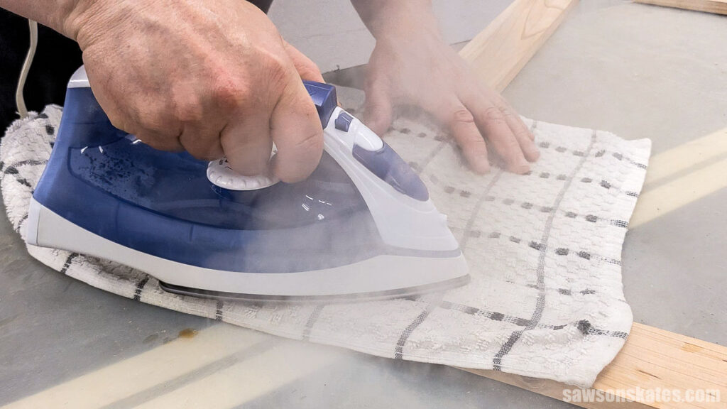 Using a clothes iron on a board