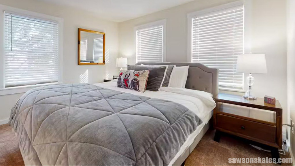 Handmade mid-century modern nightstand next to a large bed