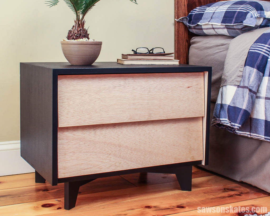 DIY two-drawer mid-century modern-style nightstand next to a bed