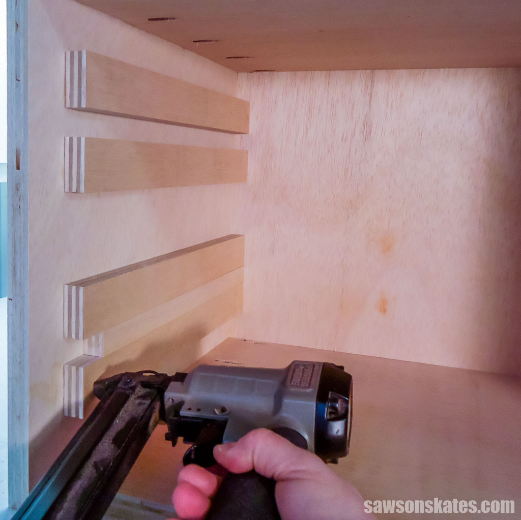 Using a brad nailer to attach the lower support to the side