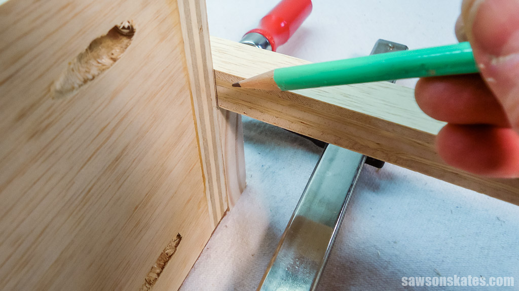 Using a pencil to mark the drawer slide for length