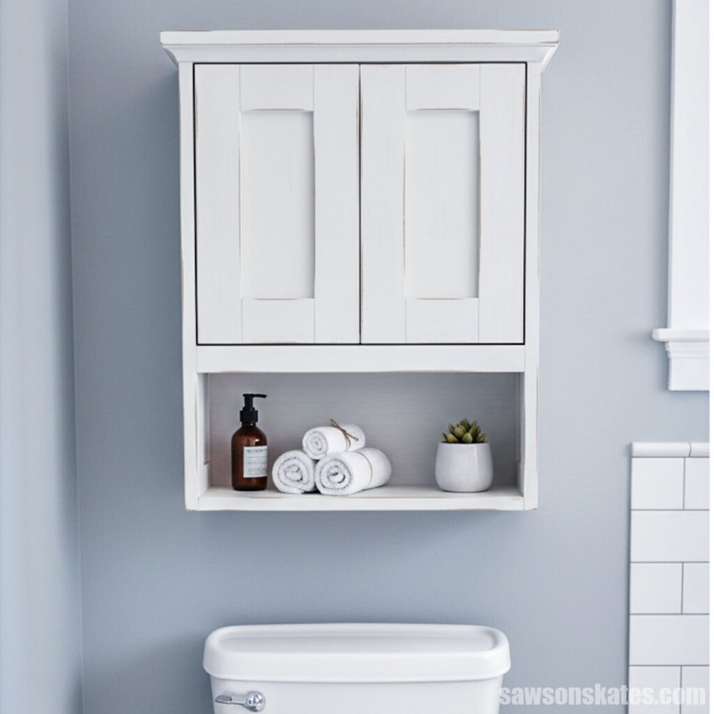 Wall-mounted cabinet with two doors and a shelf above a toilet